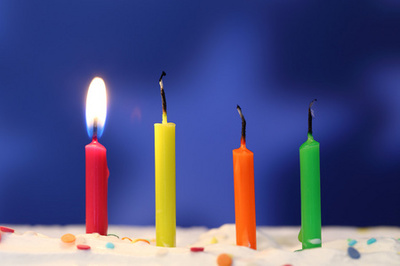 彩色燃烧生日蜡烛在黑暗的背景下